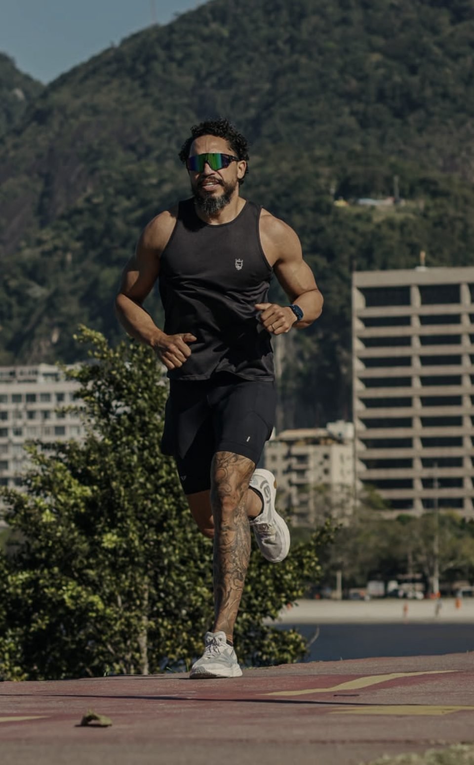 Rodrigo Victor correndo na orla do Aterro do Flamengo, com o morro e o Corcovado ao fundo